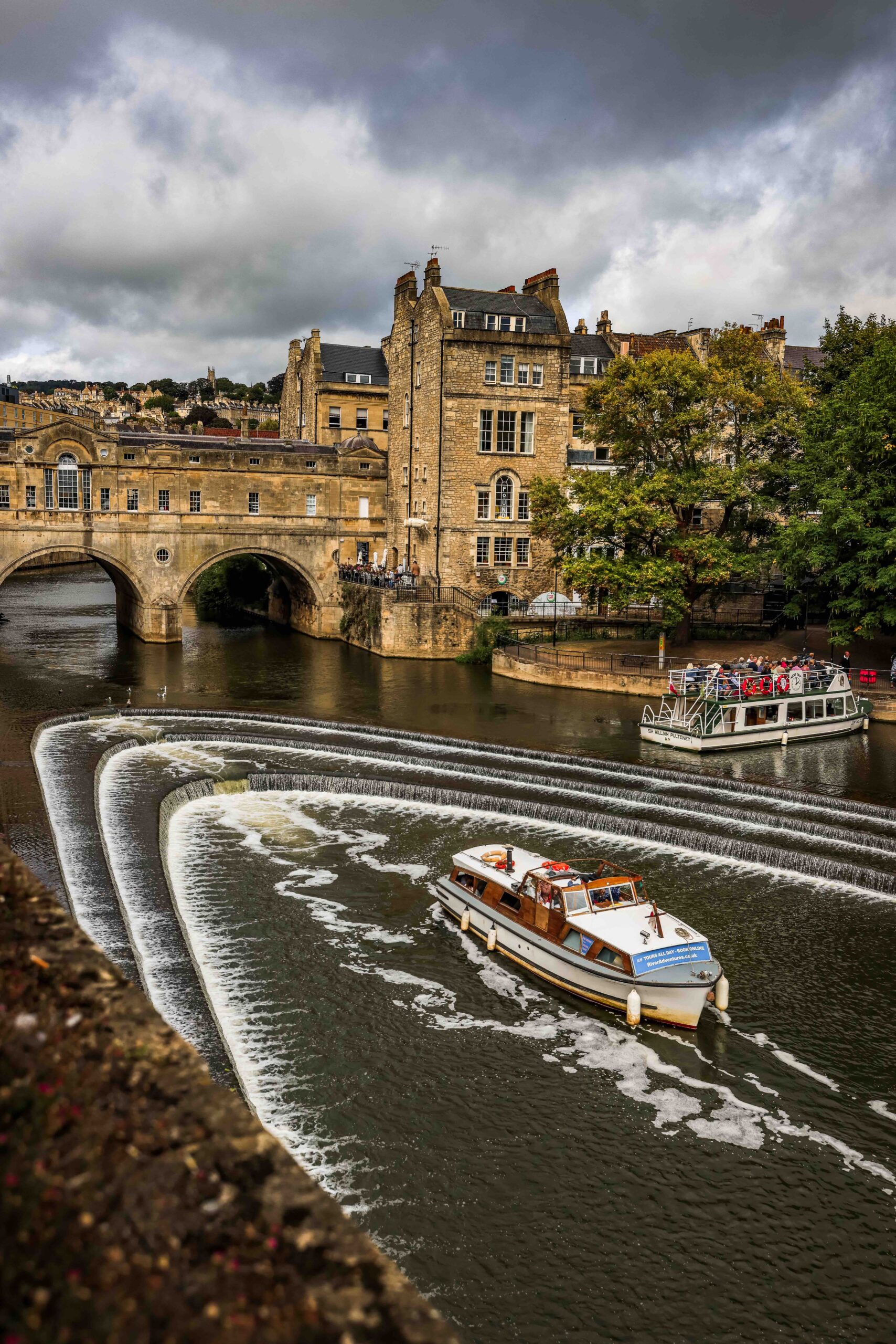 A boat is sitting on the river underneath Pultney Bridge in Bath
