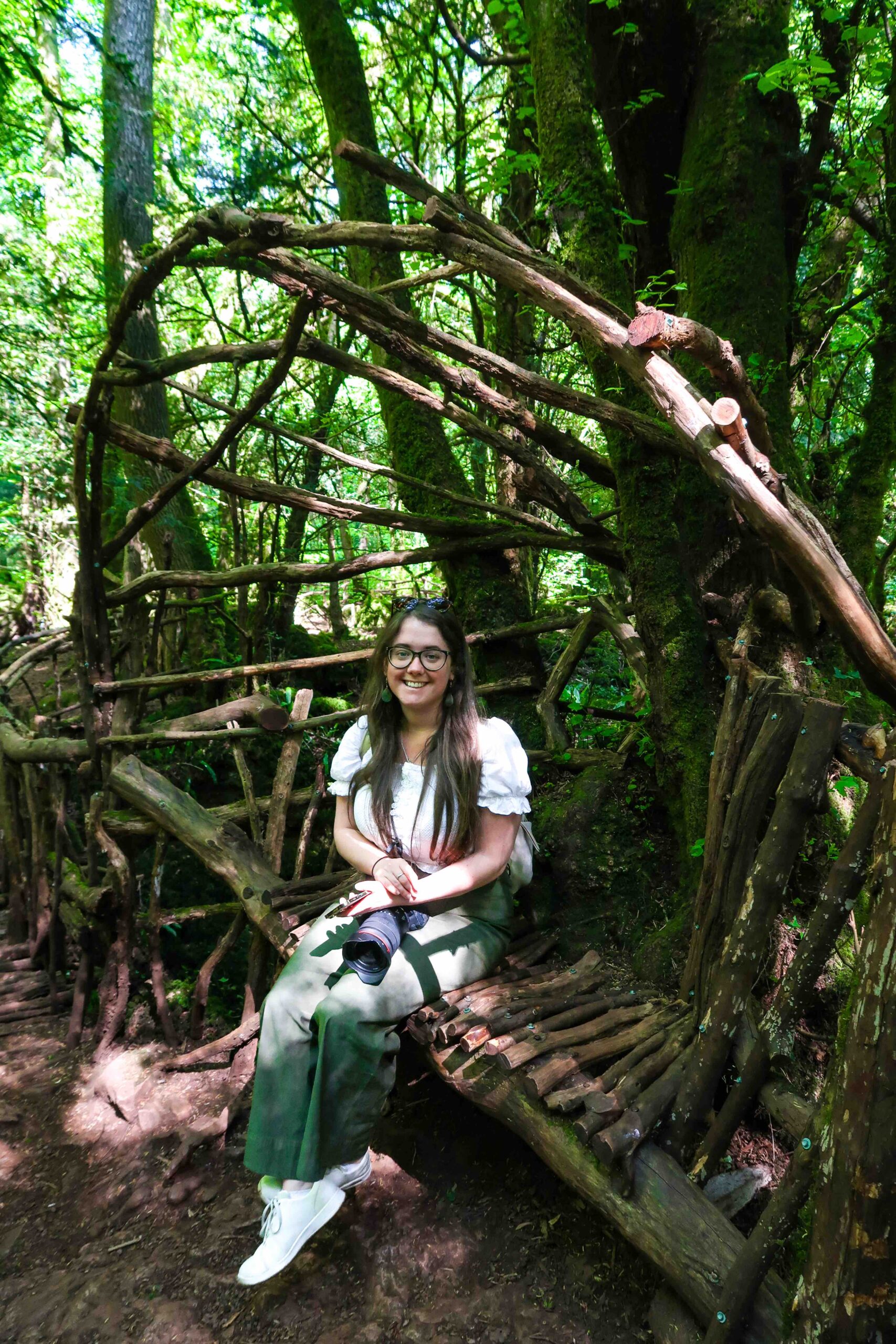 Jade Braham sitting in Puzzlewood Forest.