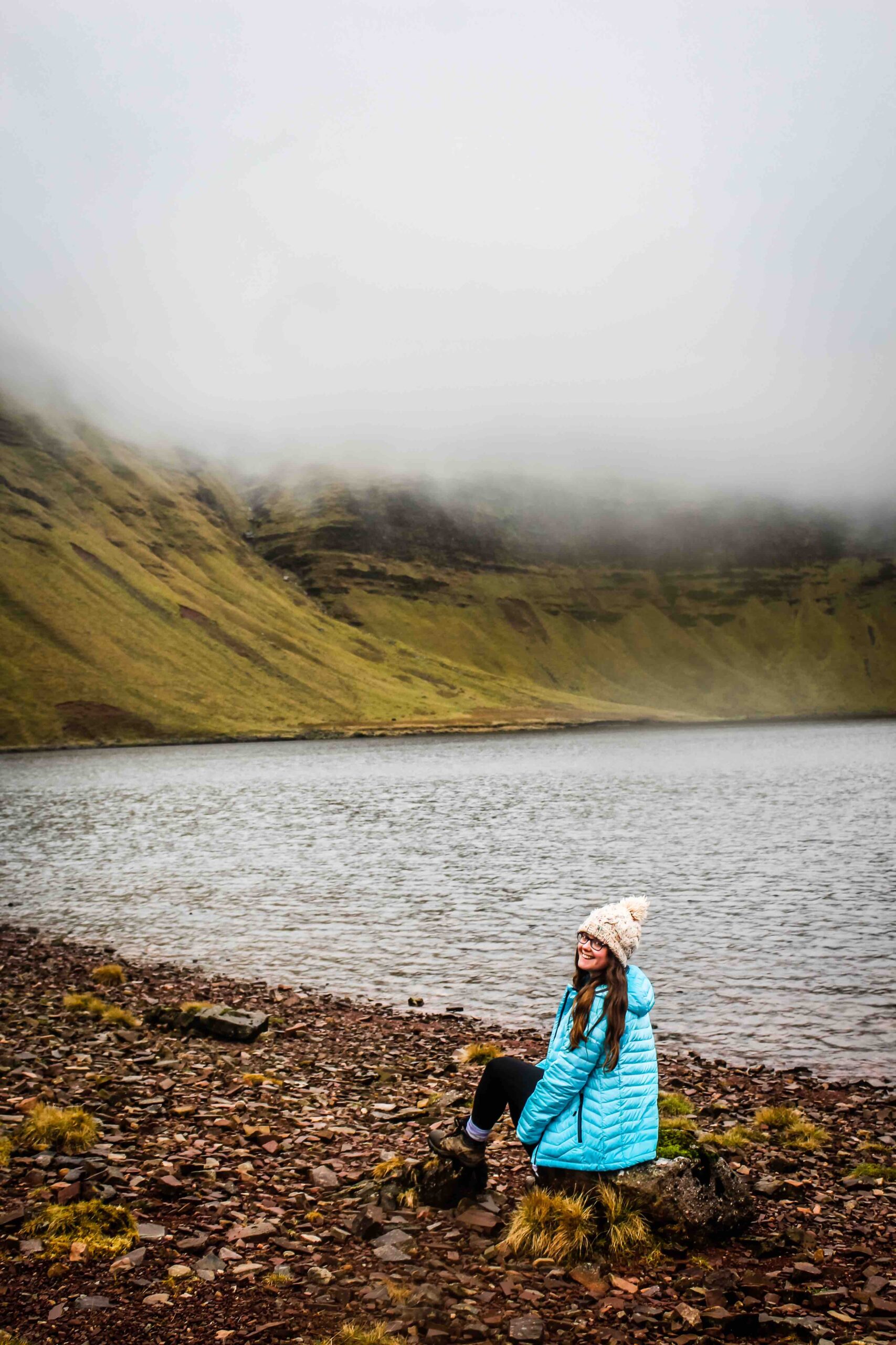 Jade Braham sitting in front of the lake at Llyn y Fan Fach