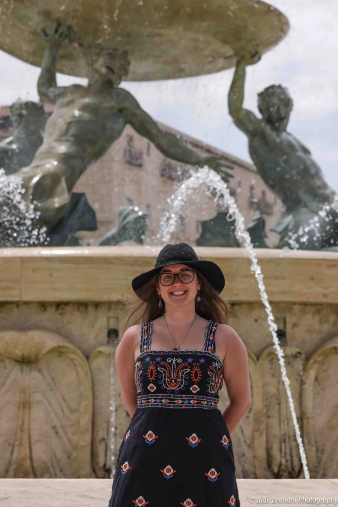 Jade Braham is standing in front of Triton Fountain, which is one of the best things to do in Valletta.