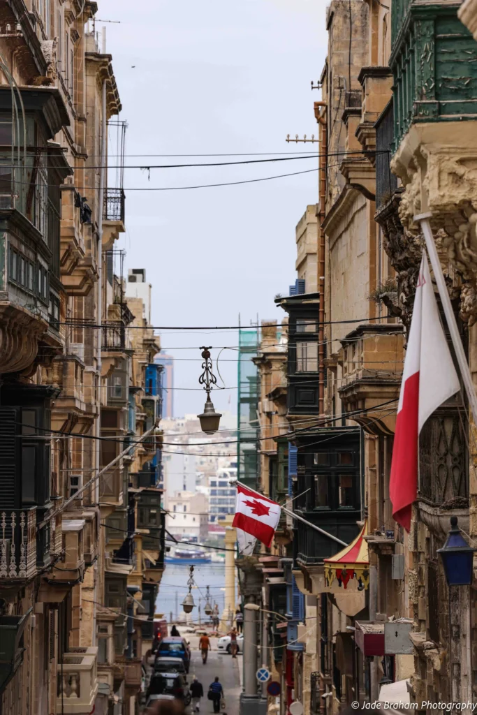 The streets in valletta have wonderfully painted balconies, flags and coastal views.