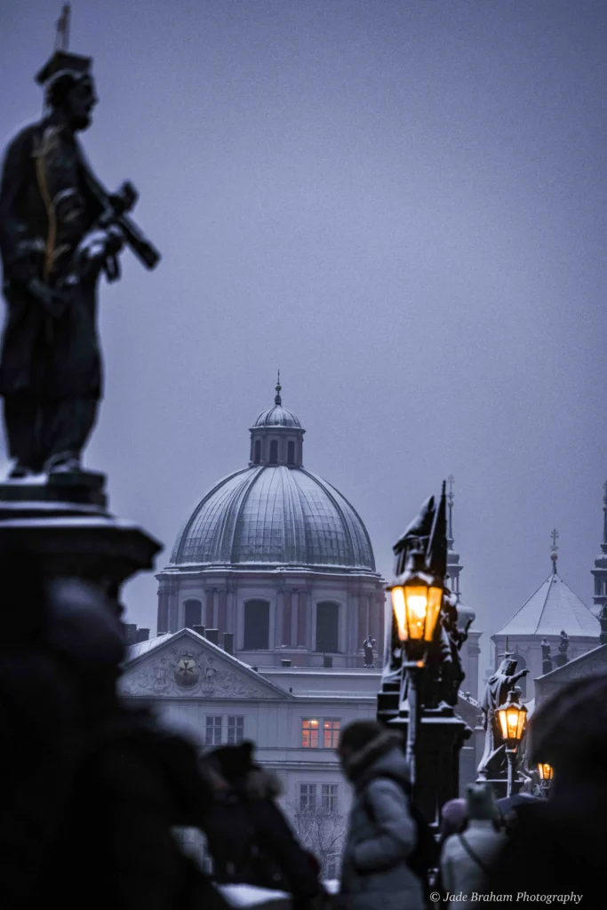 The Charles Bridge in Prague is covered with snow. 