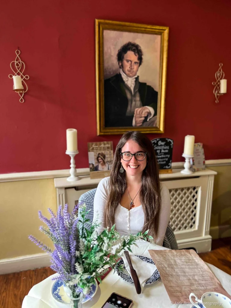 Jade Braham sitting in front of a portrait of Mr Darcy