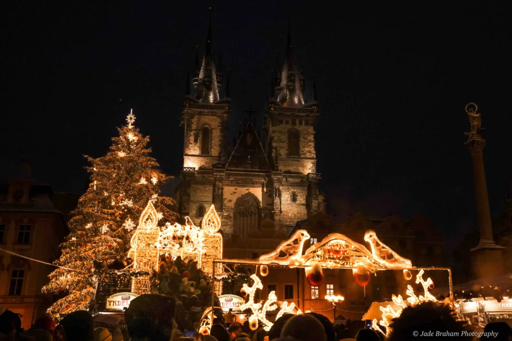 Prague Cathedral in the Old Town is lit up with lights and it's nighttime. 