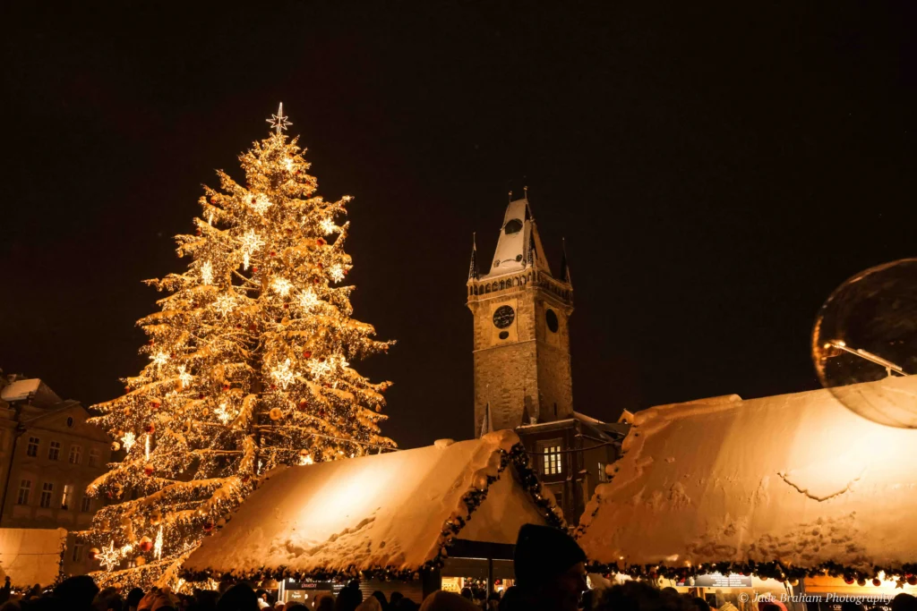 Prague Cathedral in the Old Town is lit up with lights and it's nighttime. 