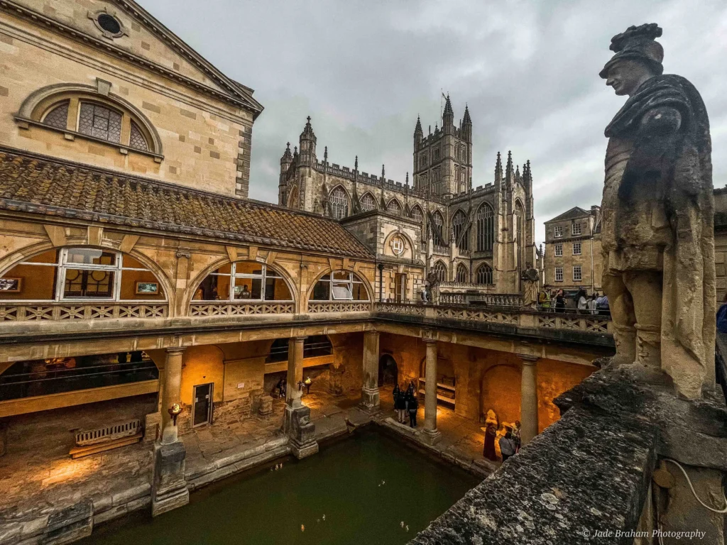 The Roman Baths in Bath, England with Bath Abbey in the background.