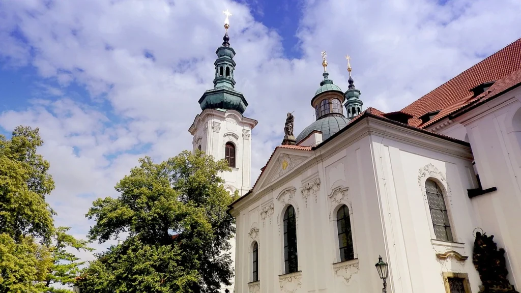 Strahov Library facade is white with terracotta red roof and blue tower spires. 