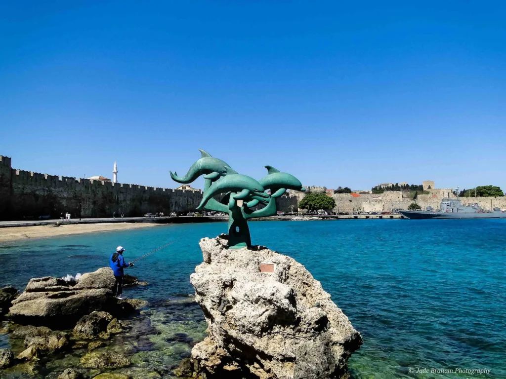 Rhodes harbour has statues of three dolphins.