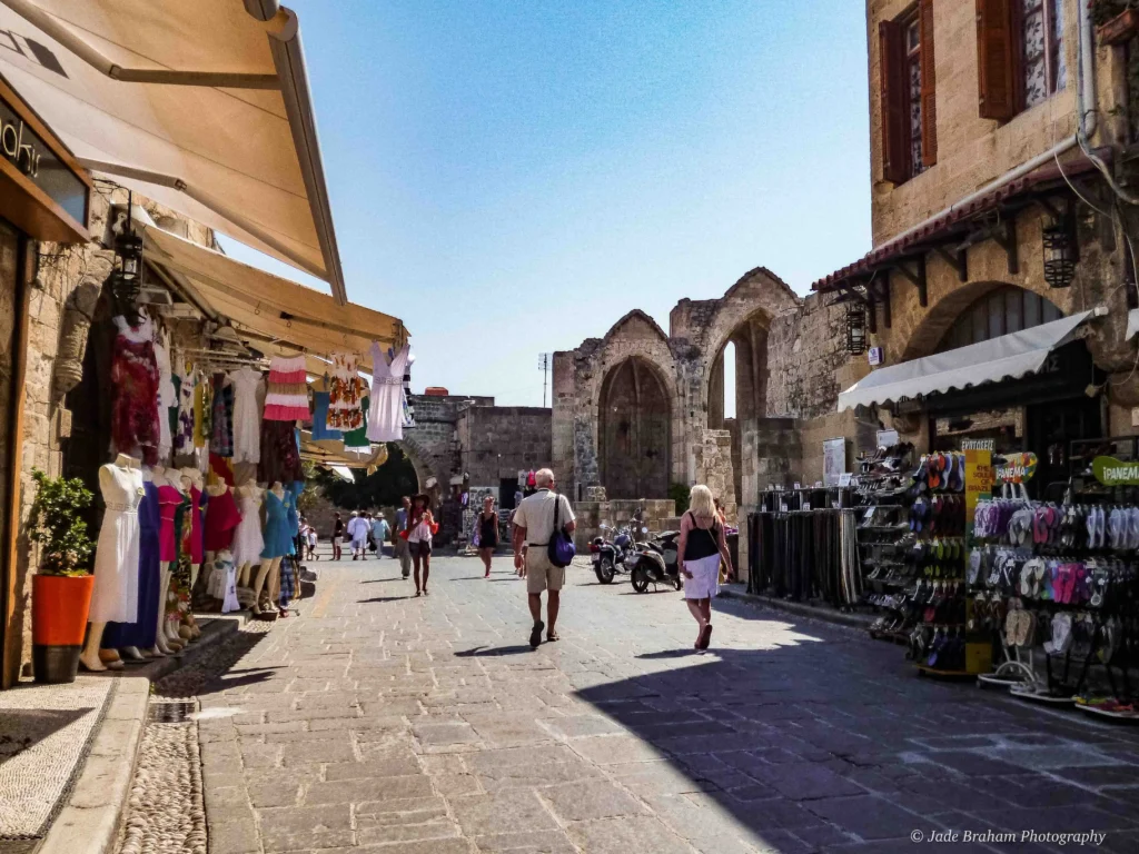 Rhodes town centre is filled with shops with displays outside.