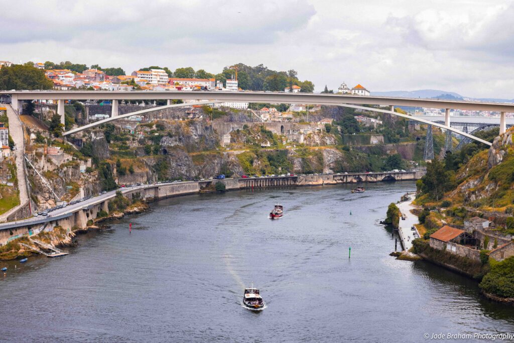 Boats gliding under the Luis I Bridge