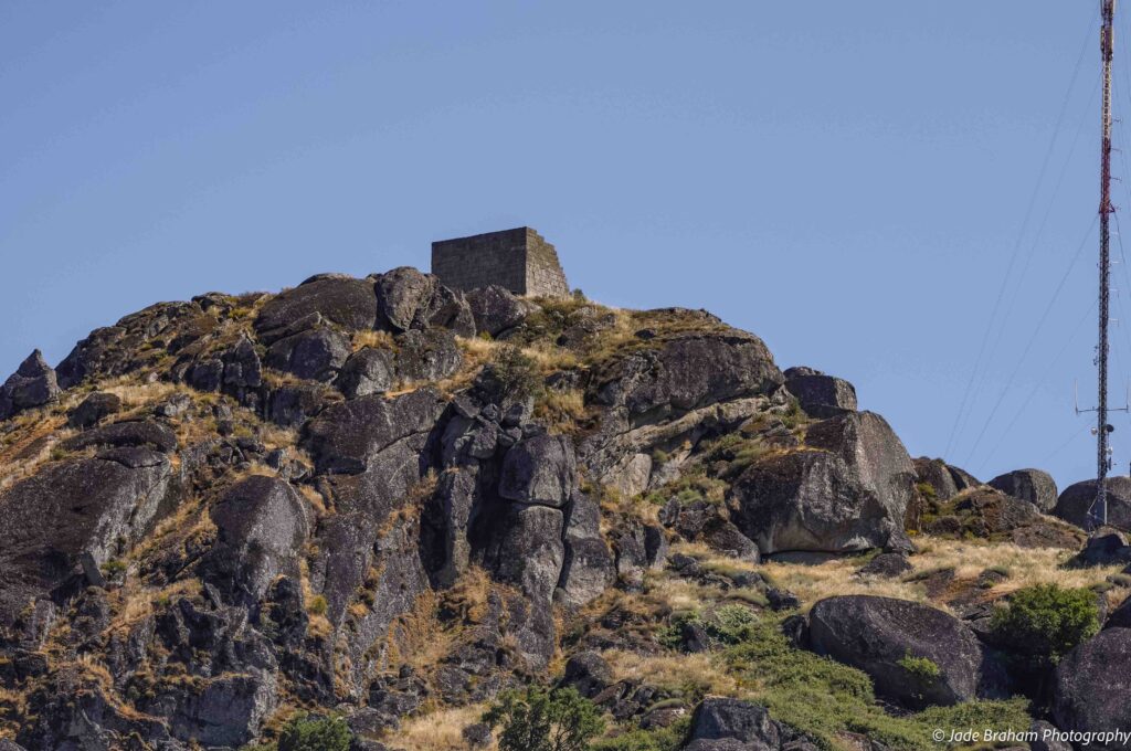 View of Monsanto Castle at the top of a hill