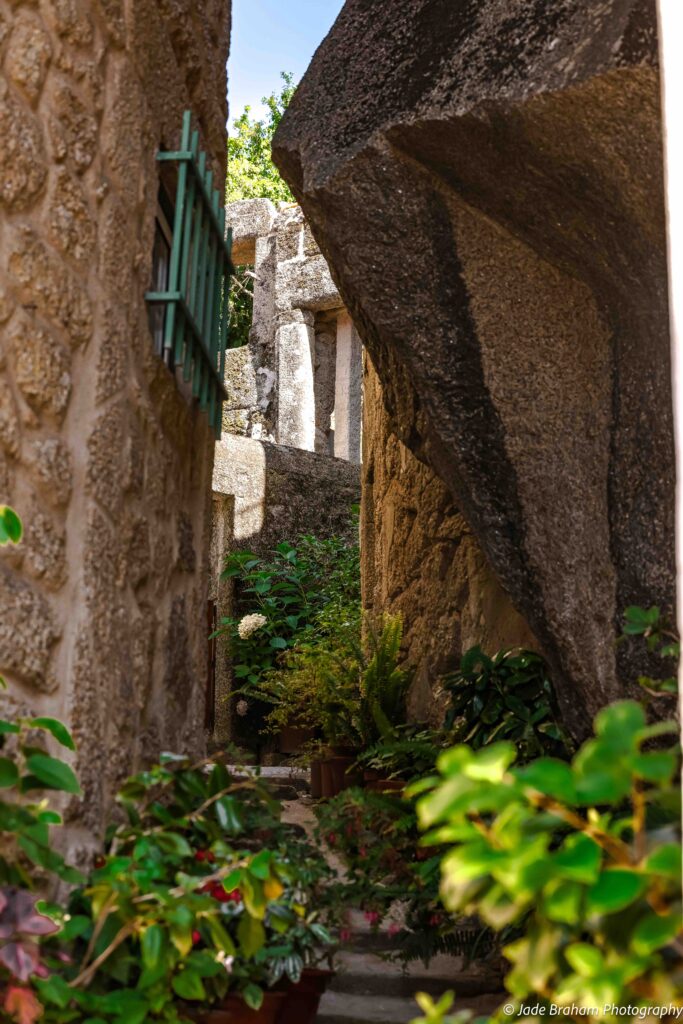 Narrow streets are cut up by sharp boulders and potted plants.