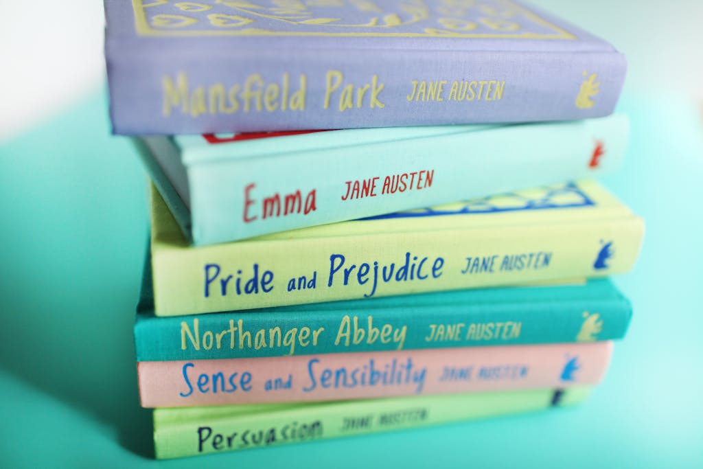 A vibrant stack of Jane Austen books against a pastel background, showcasing classic literature.